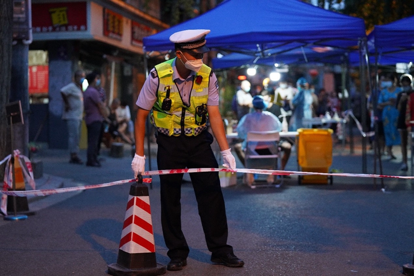 成都交警五分局警员提前来到核酸检测点,跟着社区工作人员一起规划检测点的设置.jpg