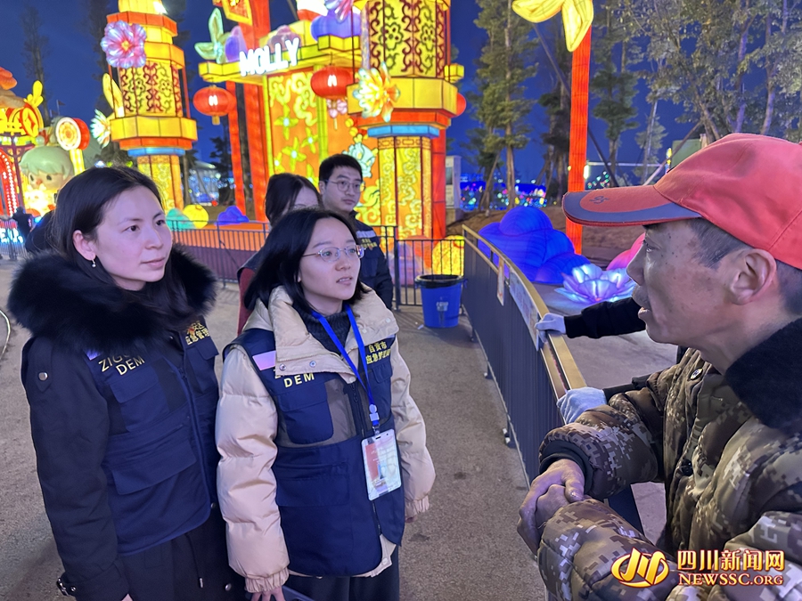 刘明洁（左一）与官子欣在灯会现场与施工人员沟通.jpg