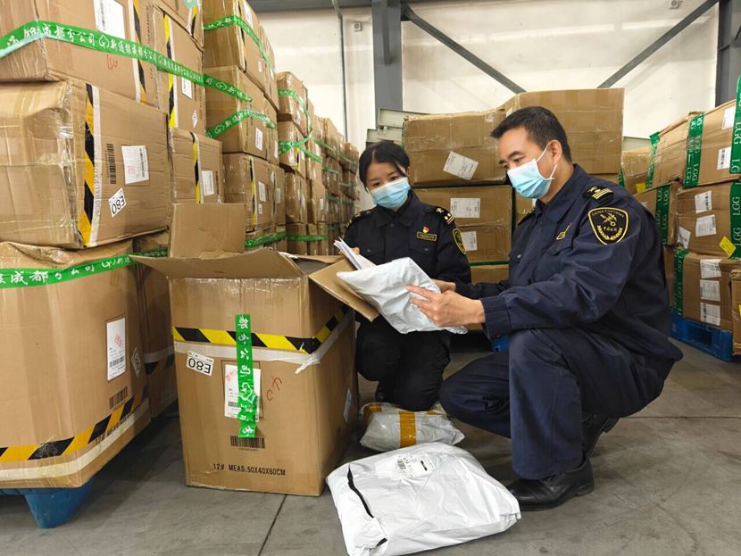 成都双流机场海关关员闫军、林璐萌正在查验出口跨境电商商品(成都海关供图).jpg