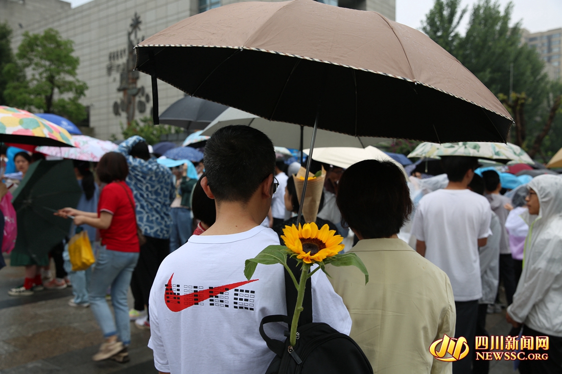 成都石室天府中学考点外，考生背上寓意“一举夺魁”的向日葵.jpg