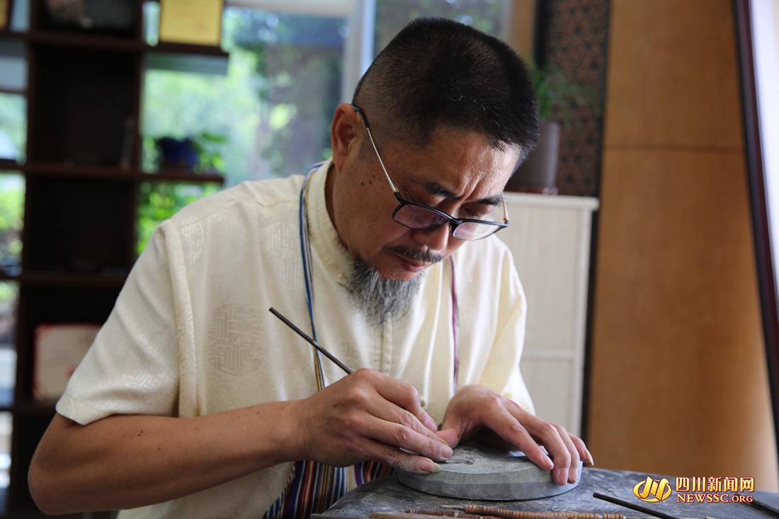 任述斌正在进行苴却砚雕刻创作.jpg
