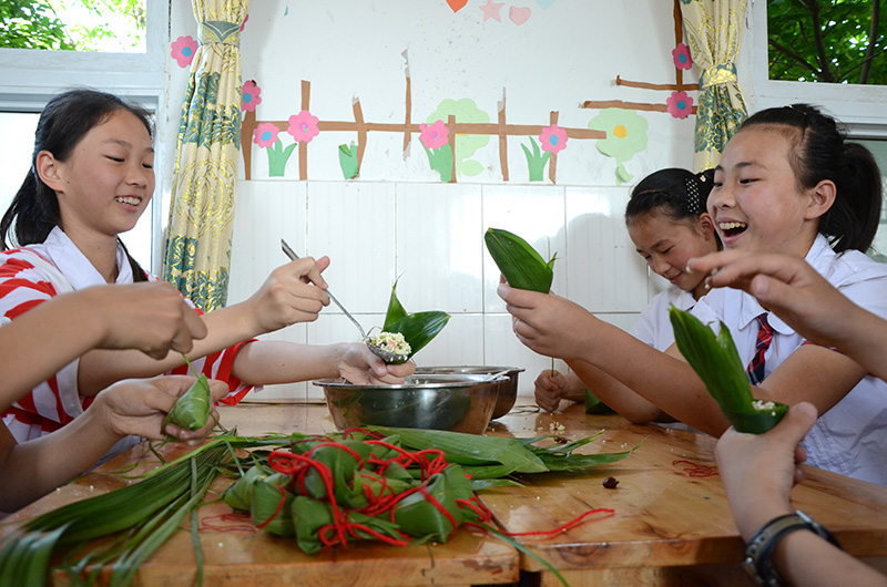 胡市镇来龙学校的学生正在包粽子，体验传统民俗文化