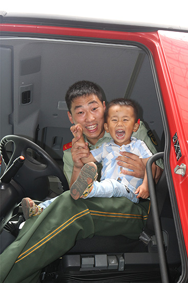 父子一起坐上消防车-自贡消防支队供图-张文婷摄影